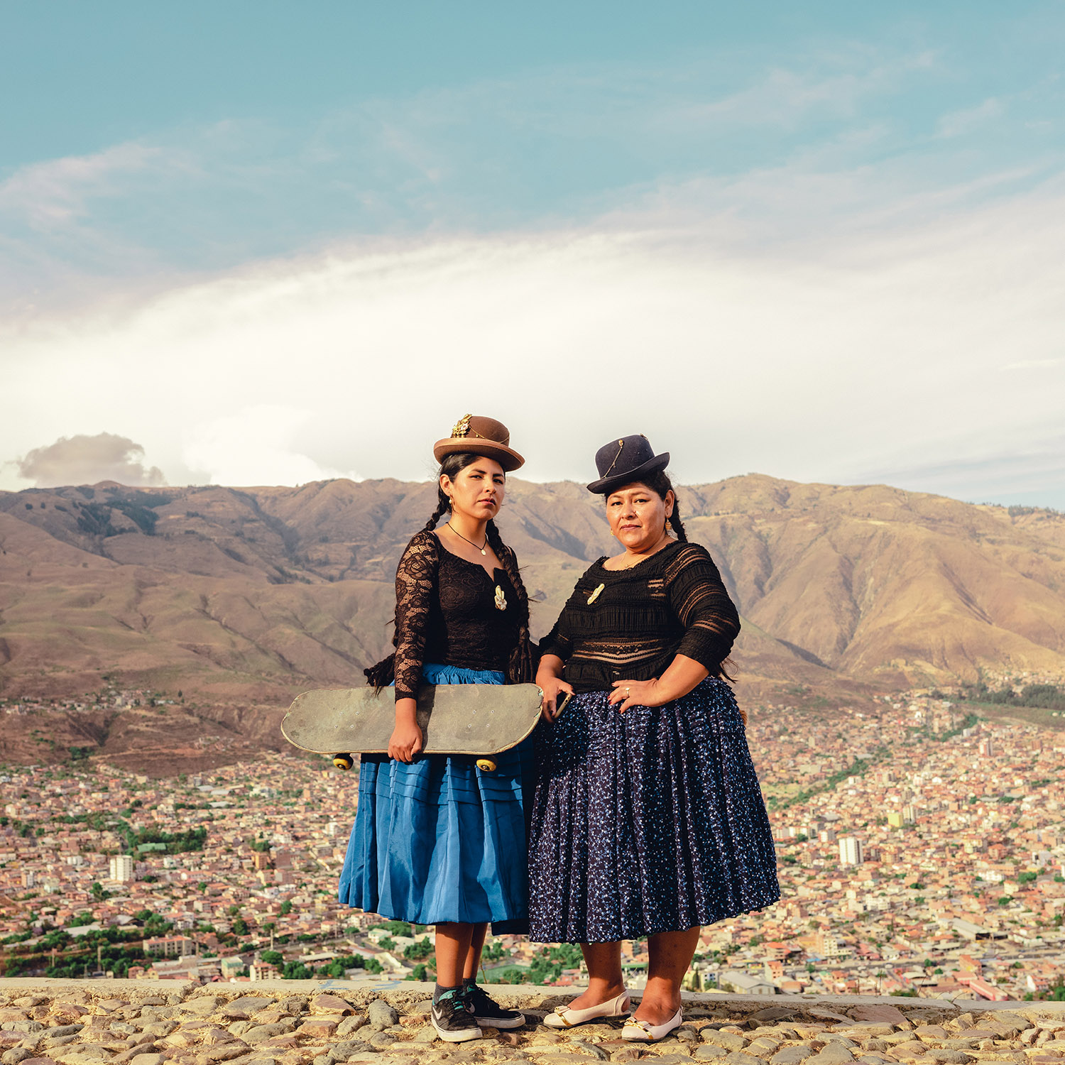 due donne boliviane con skateboard e polleras